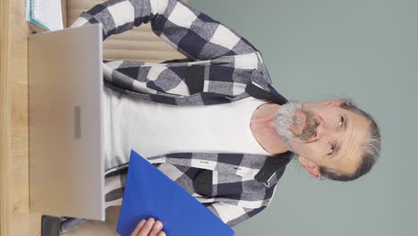 Vertical-video-of-The-old-man-looking-at-the-documents-is-thoughtful.
